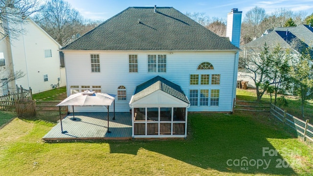 rear view of property with a sunroom and a lawn