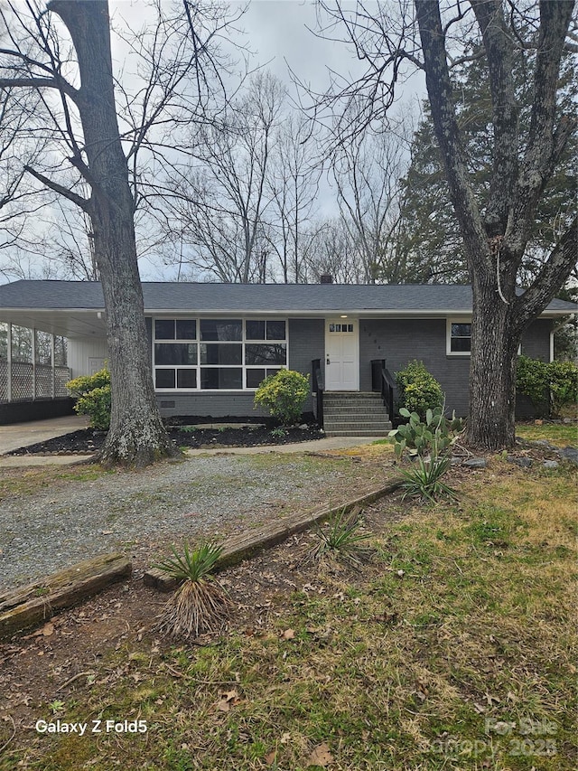 view of front facade with gravel driveway and a carport