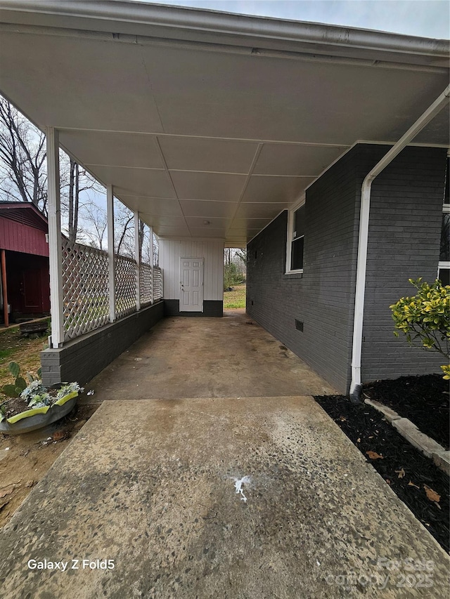 view of parking / parking lot with a carport and concrete driveway