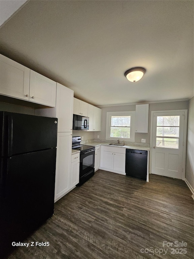 kitchen featuring dark wood-style flooring, white cabinets, a sink, and black appliances