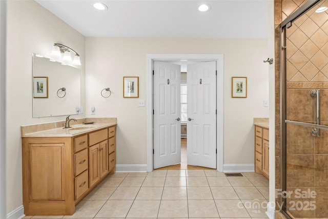 bathroom with vanity, an enclosed shower, and tile patterned floors