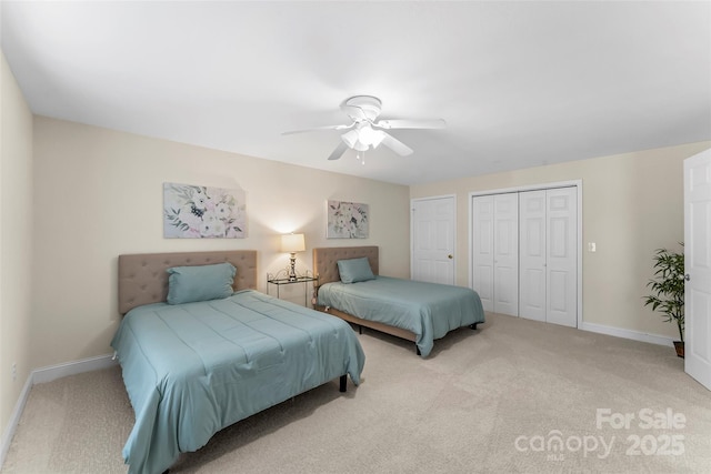 bedroom featuring multiple closets, light colored carpet, and ceiling fan