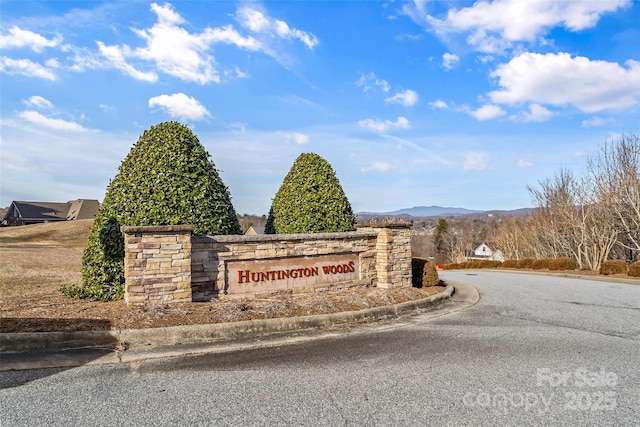 community / neighborhood sign with a mountain view