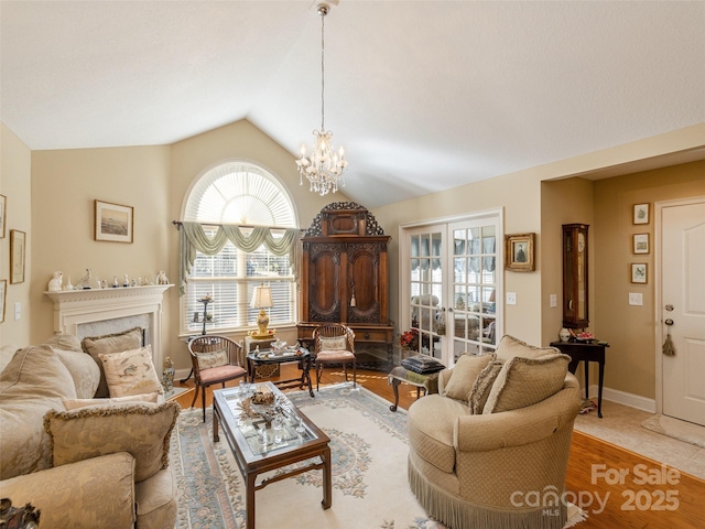 living room with a fireplace, lofted ceiling, light tile patterned floors, an inviting chandelier, and french doors