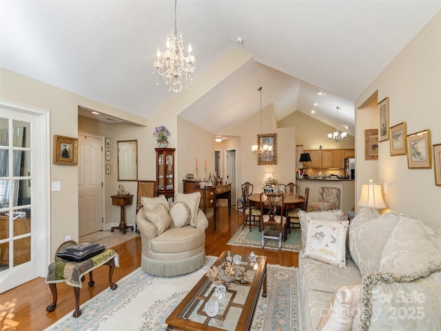 living room featuring an inviting chandelier, hardwood / wood-style flooring, and high vaulted ceiling