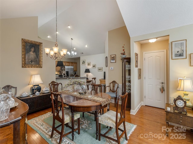 dining space featuring lofted ceiling and light hardwood / wood-style flooring