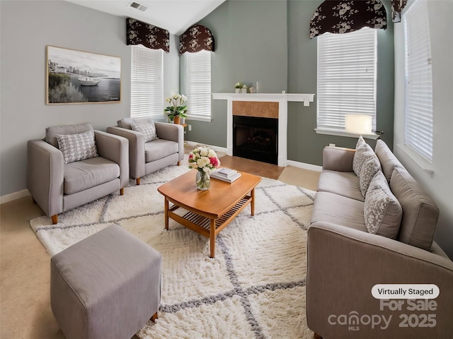 carpeted living room with a tile fireplace and plenty of natural light