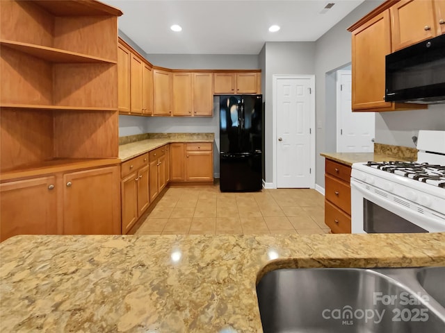 kitchen with light stone countertops, sink, light tile patterned floors, and black appliances