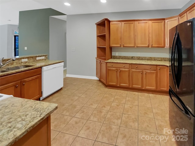 kitchen featuring dishwasher, black fridge, sink, and light tile patterned floors