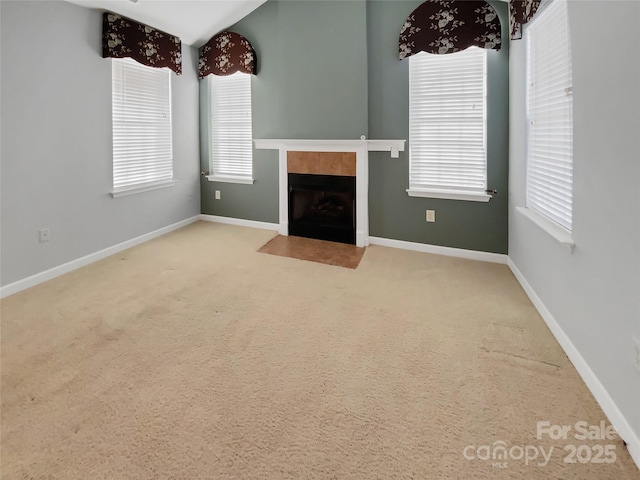 unfurnished living room with carpet floors and a tile fireplace