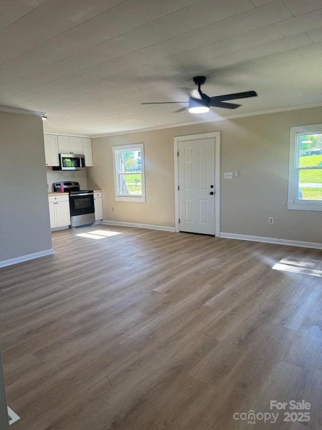 unfurnished living room with ornamental molding, light hardwood / wood-style flooring, and a wealth of natural light