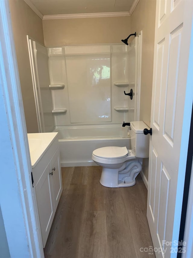 full bathroom featuring vanity, hardwood / wood-style flooring, ornamental molding, and toilet