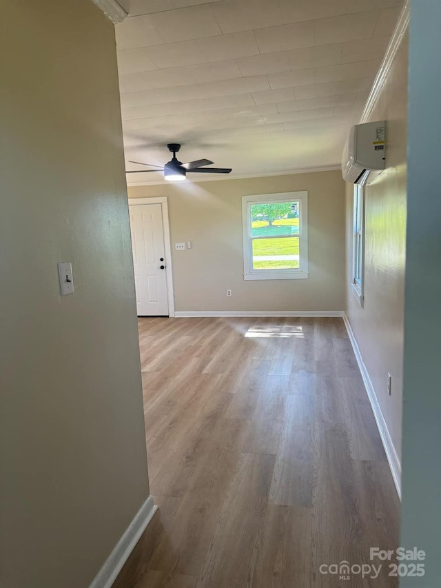 spare room featuring ceiling fan, ornamental molding, hardwood / wood-style floors, and a wall unit AC