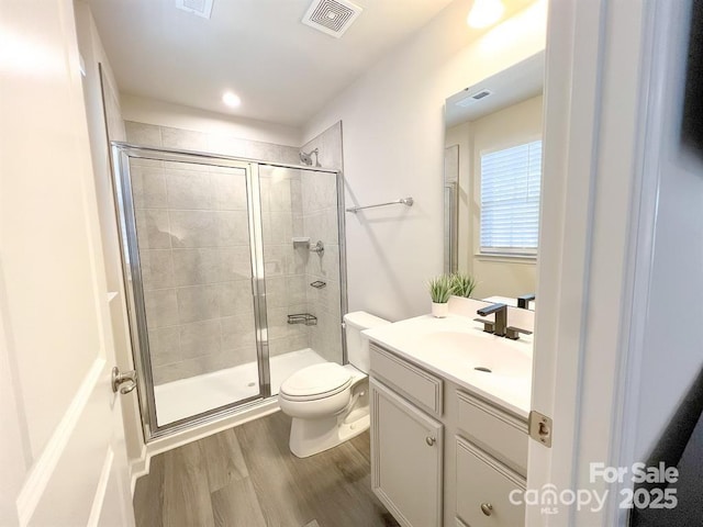 bathroom with vanity, hardwood / wood-style floors, walk in shower, and toilet