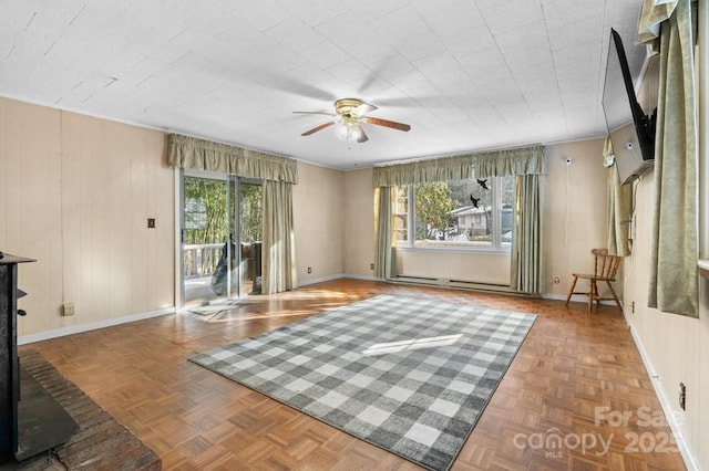 interior space with ceiling fan, parquet flooring, and a baseboard heating unit