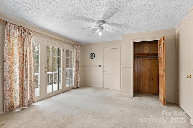 unfurnished bedroom featuring ceiling fan, a textured ceiling, light carpet, access to outside, and a closet