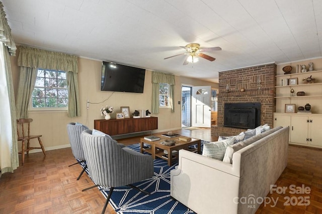 living room featuring parquet floors, a brick fireplace, and ceiling fan