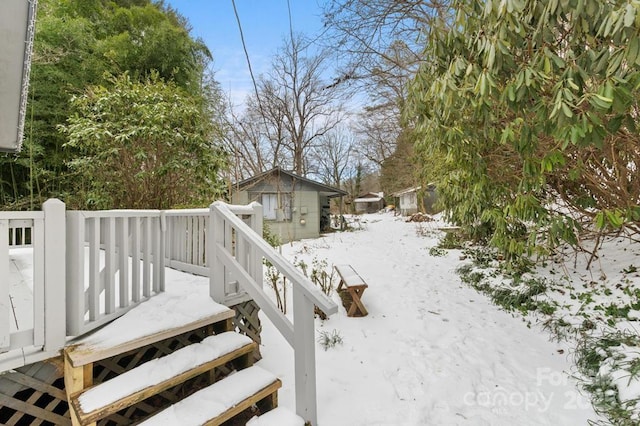 yard layered in snow with a wooden deck