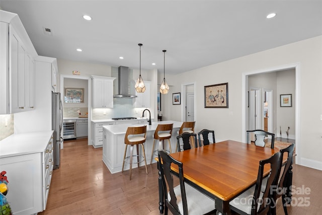 dining room featuring wine cooler and light wood-type flooring