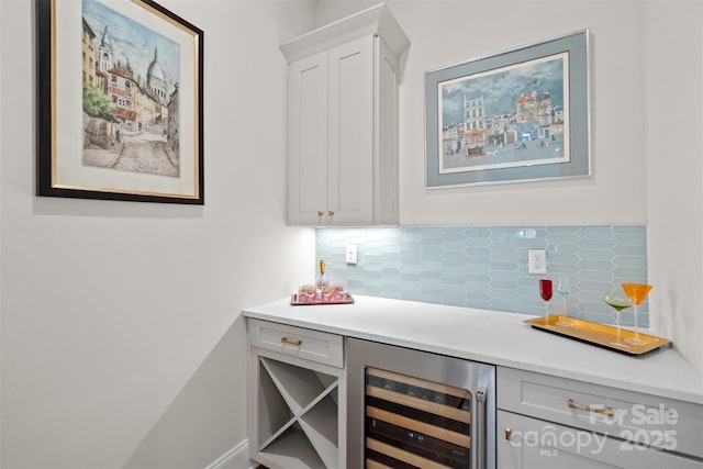 bar featuring white cabinets, wine cooler, and backsplash