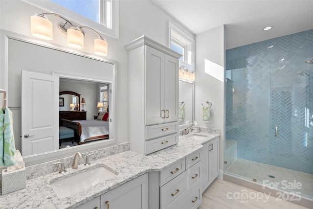 bathroom featuring an enclosed shower and vanity