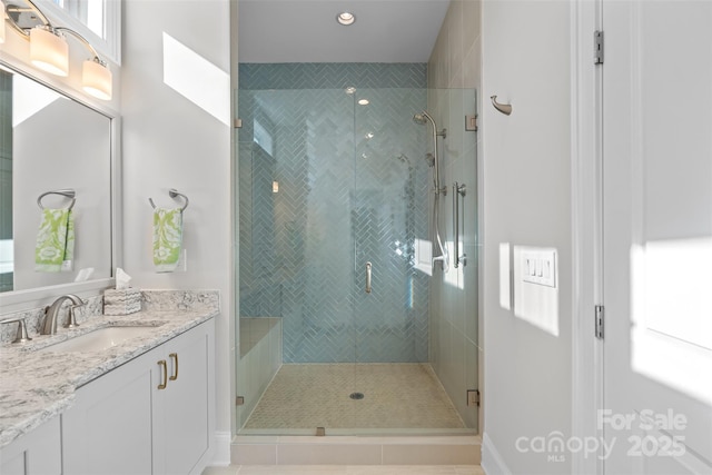 bathroom featuring vanity and a shower with door