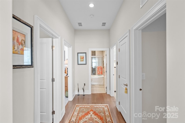 corridor with light hardwood / wood-style flooring