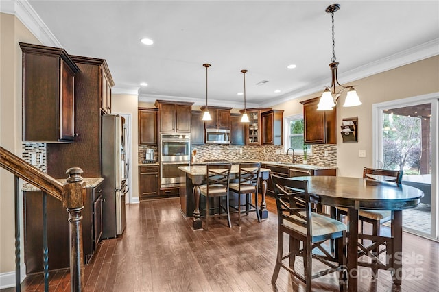 dining room with crown molding, plenty of natural light, dark hardwood / wood-style floors, and sink