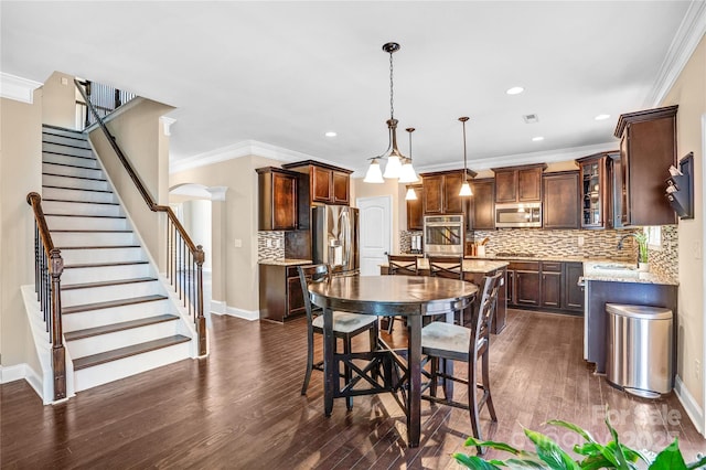 dining room with sink, crown molding, and dark wood-type flooring