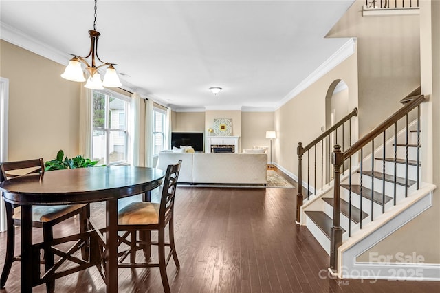 dining area featuring an inviting chandelier, dark wood-type flooring, and ornamental molding