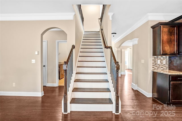 stairs with ornamental molding and hardwood / wood-style floors