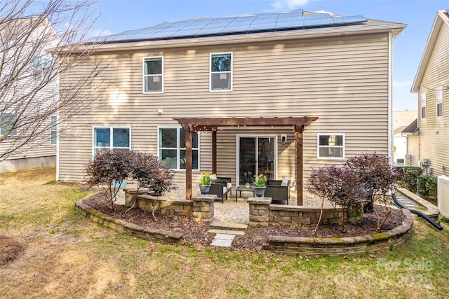 back of house with a yard, a pergola, a patio, and solar panels