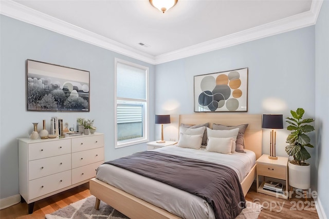 bedroom featuring light hardwood / wood-style flooring and ornamental molding