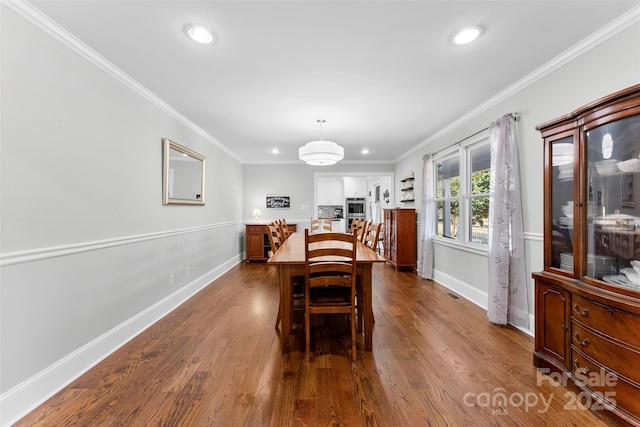 dining room featuring hardwood / wood-style flooring and crown molding