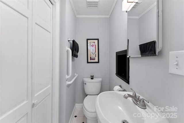 bathroom with sink, ornamental molding, and toilet