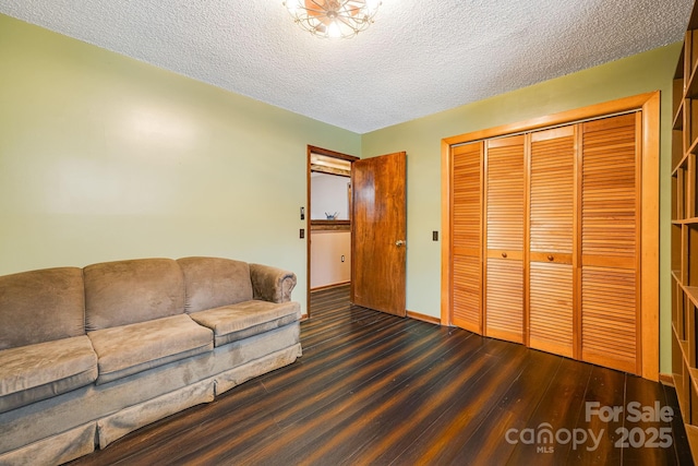 living room featuring a textured ceiling, wood finished floors, and baseboards