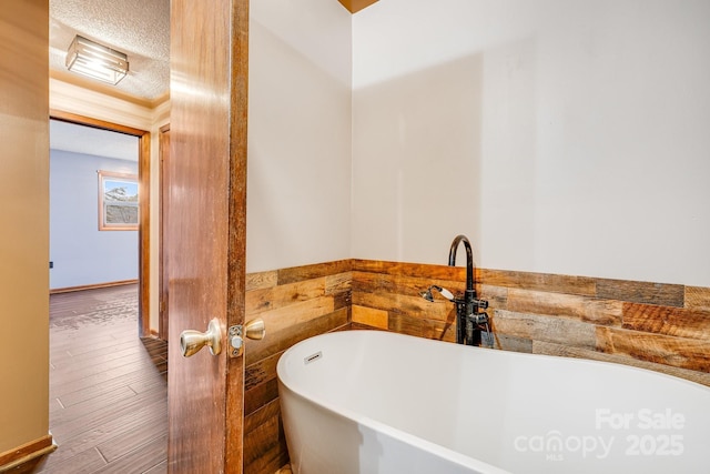 full bathroom featuring a freestanding tub and wood finished floors