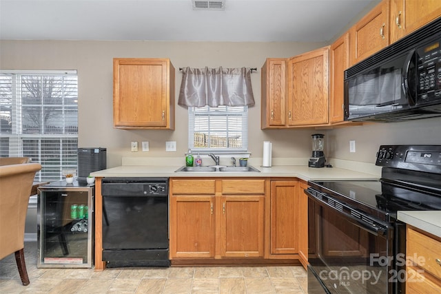 kitchen with wine cooler, sink, and black appliances