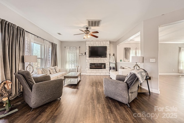 living room featuring ceiling fan, dark wood-type flooring, and a fireplace