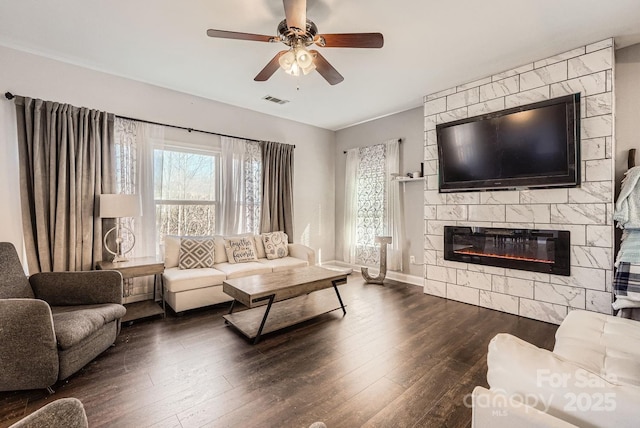 living room featuring a tile fireplace, ceiling fan, and dark hardwood / wood-style flooring