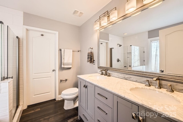 bathroom with a shower with door, vanity, hardwood / wood-style flooring, and toilet