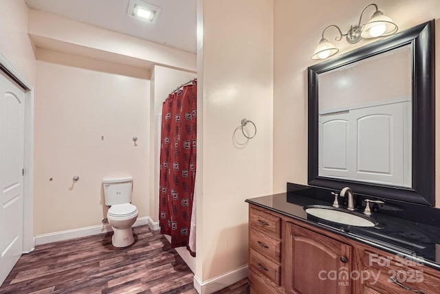 bathroom featuring vanity, hardwood / wood-style floors, a shower with shower curtain, and toilet