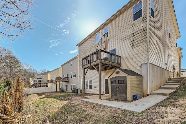 rear view of house featuring a balcony and a storage shed