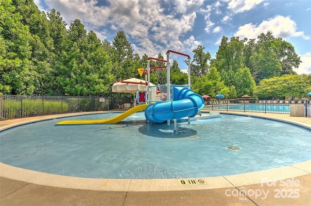 view of swimming pool with a playground and a water slide