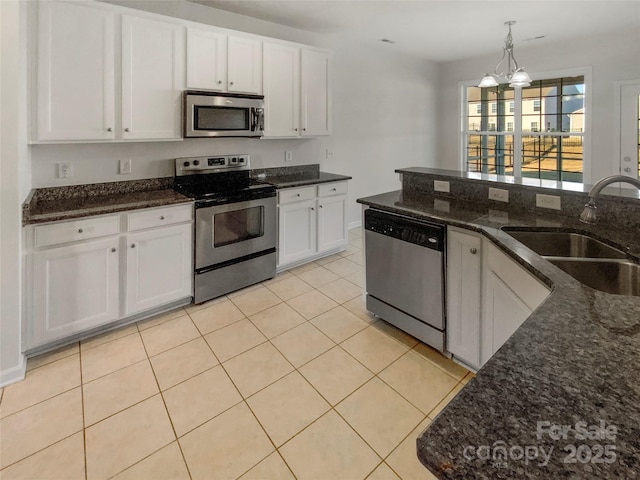 kitchen featuring pendant lighting, sink, white cabinetry, dark stone countertops, and stainless steel appliances