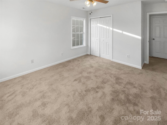 unfurnished bedroom featuring ceiling fan, a closet, and carpet