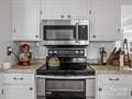 kitchen featuring backsplash, stainless steel appliances, and white cabinets