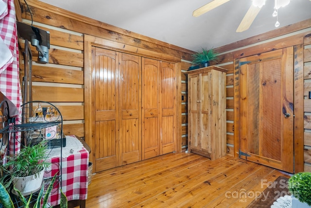 interior space featuring light hardwood / wood-style floors and wood walls