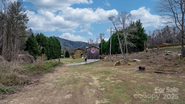 view of yard with a mountain view and a storage shed