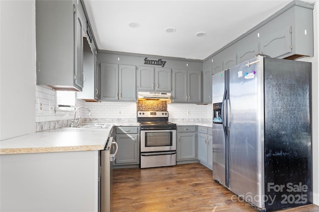 kitchen featuring appliances with stainless steel finishes, dark hardwood / wood-style floors, sink, and decorative backsplash